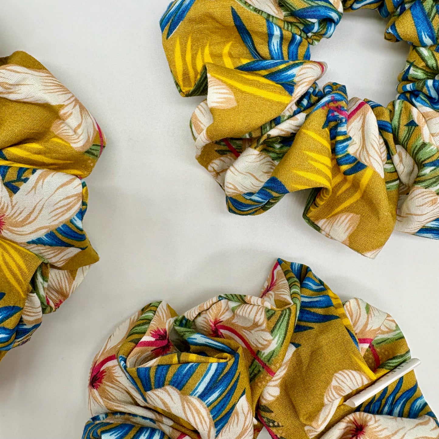 Close‑up of Hibiscus Sun print on oversized cotton scrunchie. Tropical floral pattern, breathable fabric, handmade in Kent, gentle on all hair types.
